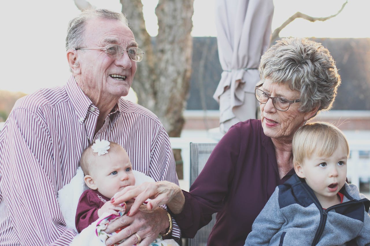 Grandmother and Grandfather Holding Child on Their Lap